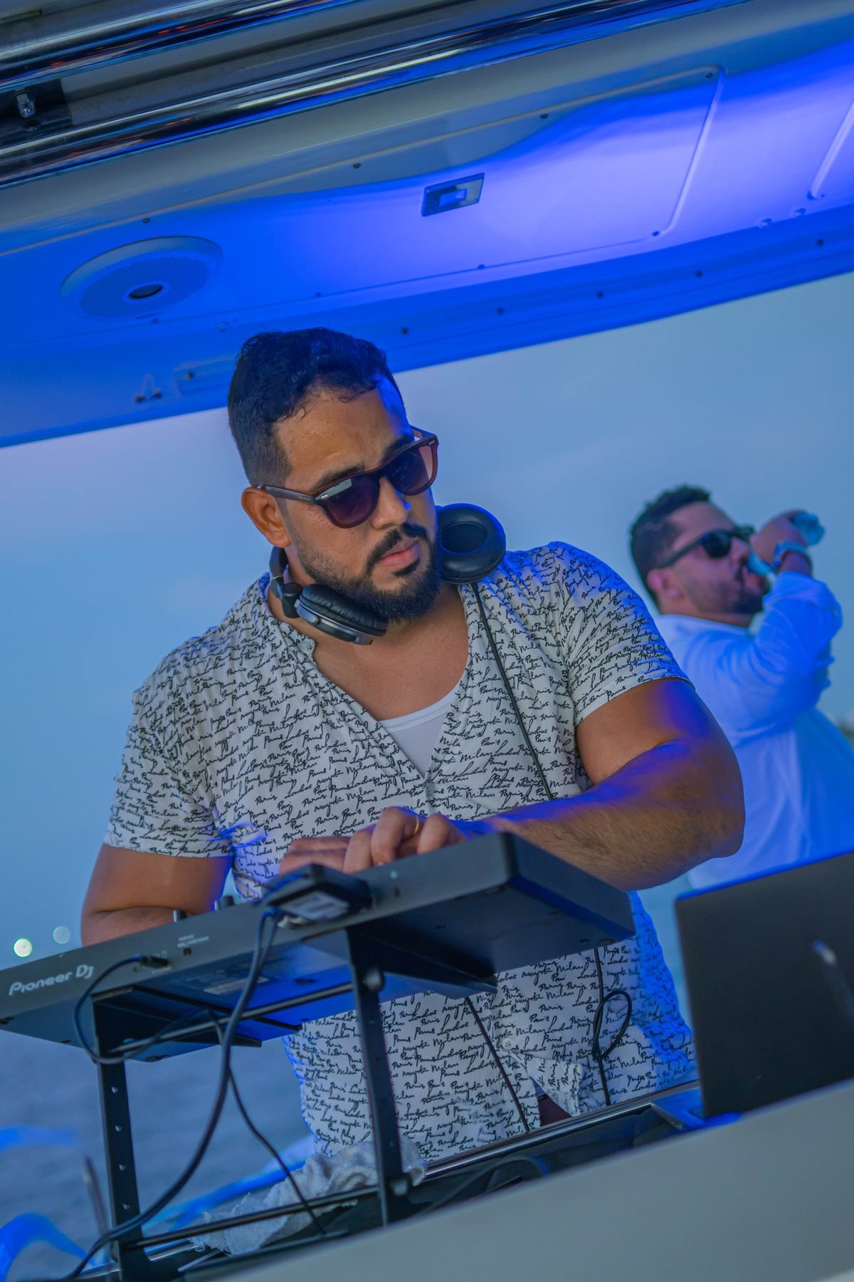 Diego Quest DJ con Pioneer DJ bajo luces azules en un yate en Cartagena