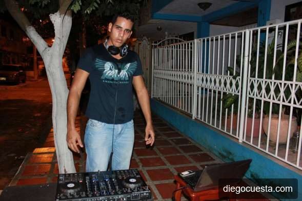 Diego Cuesta tocando como DJ en exteriores de noche con audífonos y la controladora Traktor S4
